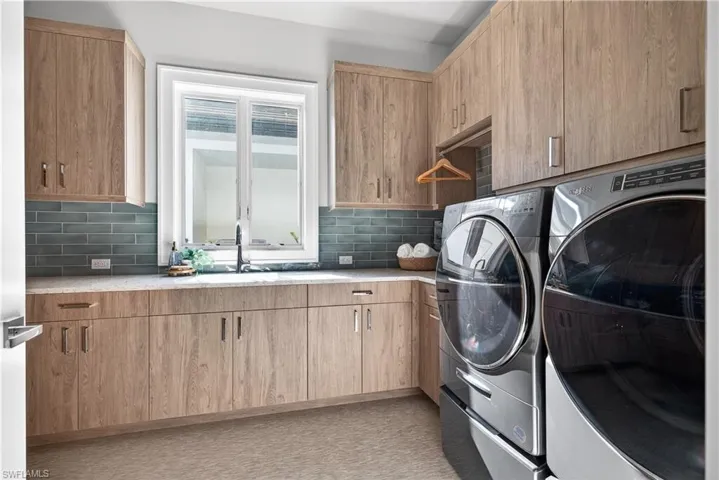 Laundry area with independent washer and dryer and cabinet space