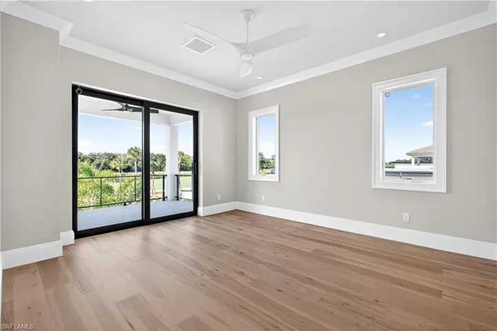 Spare room featuring ceiling fan, light wood-type flooring, and ornamental molding