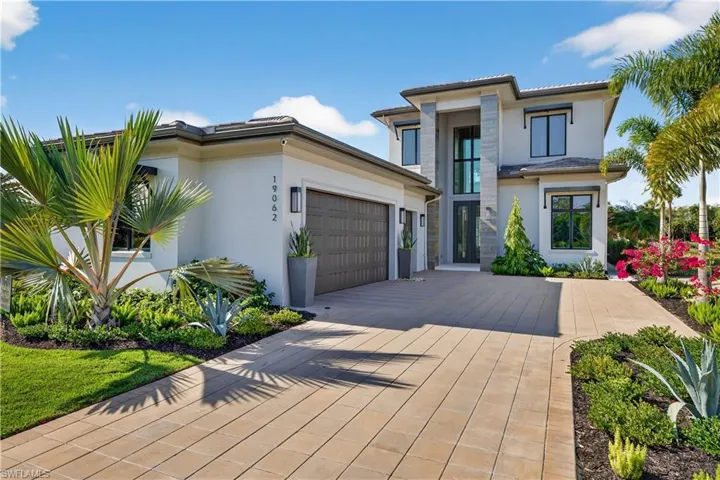 View of front of property with stucco siding, driveway, and an attached garage