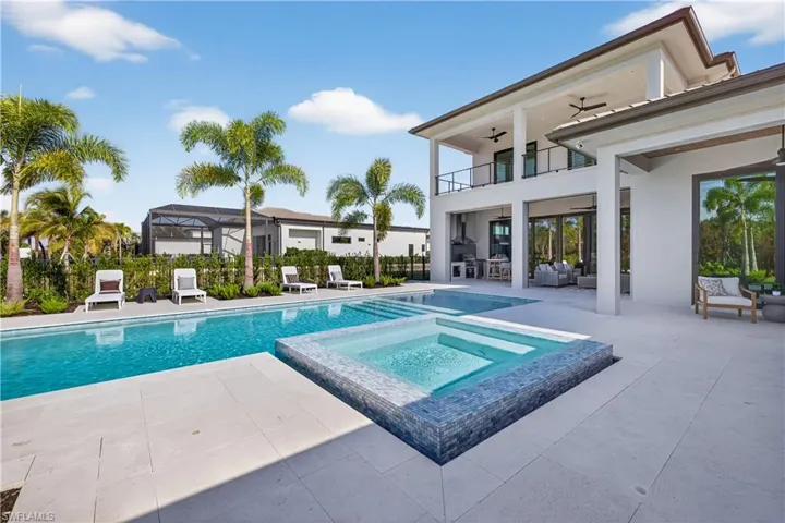 Integrated pool / hot tub featuring a balcony, a patio, glass enclosure, and an outdoor lounge area