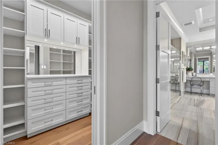 Walk in closet with light wood-style floors
