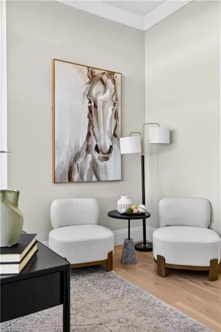 Living area with light wood-style flooring and crown molding