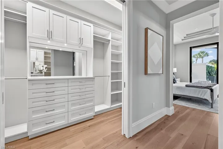 Walk in closet with light wood-type flooring