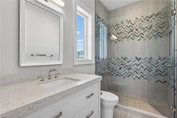 Full bathroom with vanity and a shower stall