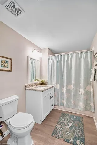 Bathroom featuring vanity, light wood-style floors, and shower / bathtub combination with curtain