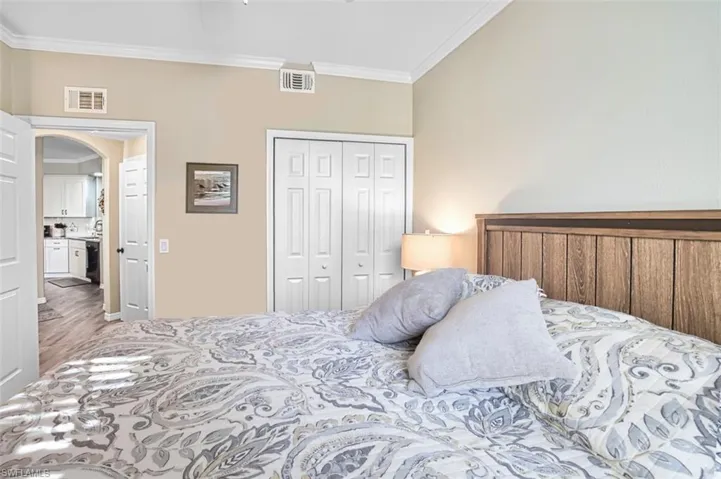 Bedroom featuring ornamental molding, arched walkways, and a closet