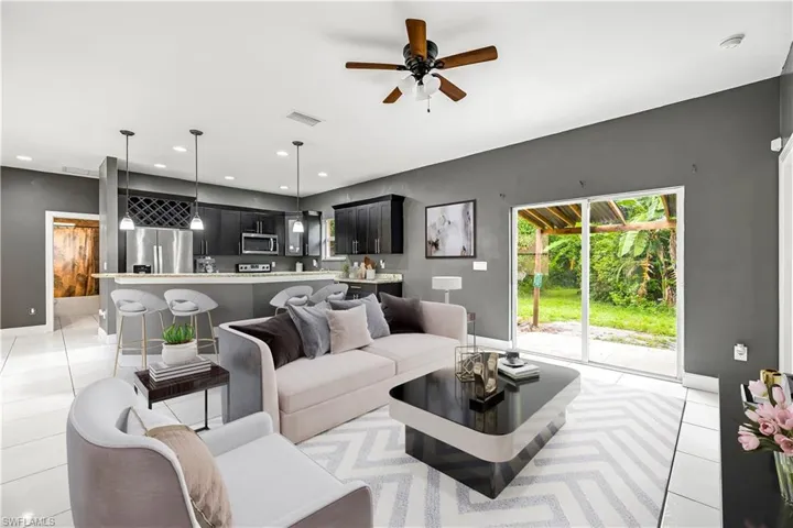 Living room featuring light tile patterned - - This photo is virtually staged floors, ceiling fan, and recessed lighting