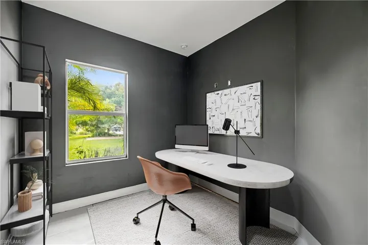 Office area with baseboards and light tile patterned floors - - This photo is virtually staged