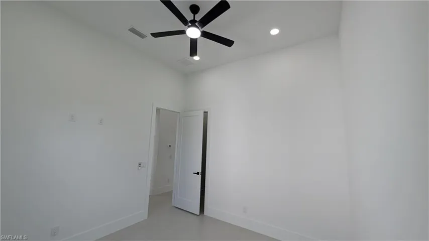 High ceilings featuring a matte black multi-blade ceiling fan with integrated lighting and recessed ceiling illumination