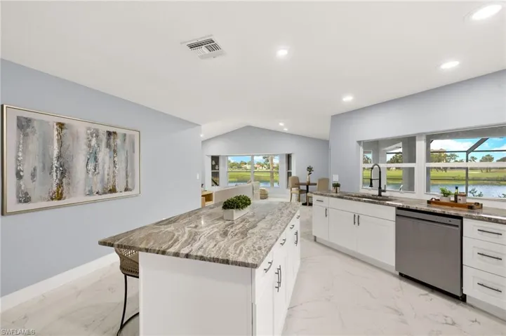 Kitchen featuring dishwasher, a sink, light marble finish flooring, light stone counters, and recessed lighting