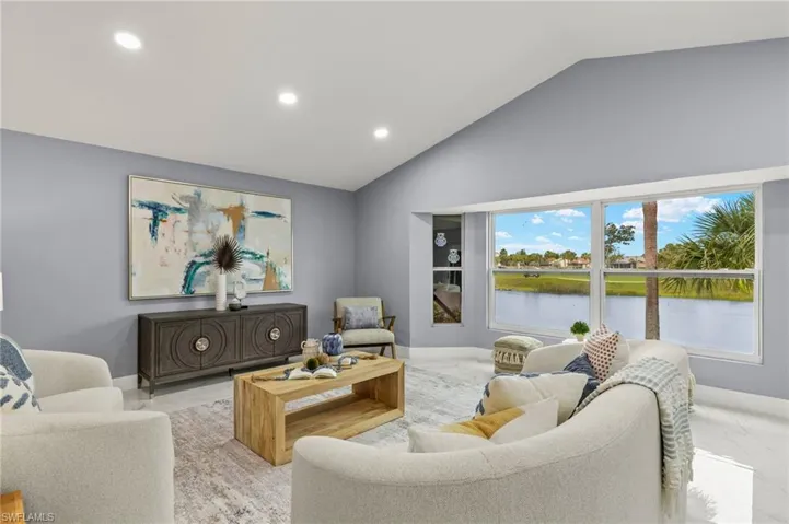 Living room featuring recessed lighting, a water view, baseboards, and high vaulted ceiling