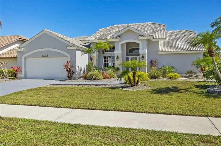 Mediterranean / spanish-style house featuring a tile roof, a garage, stucco siding, concrete driveway, and a front lawn