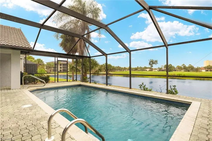 Swimming pool featuring a water view, a lanai, and a patio