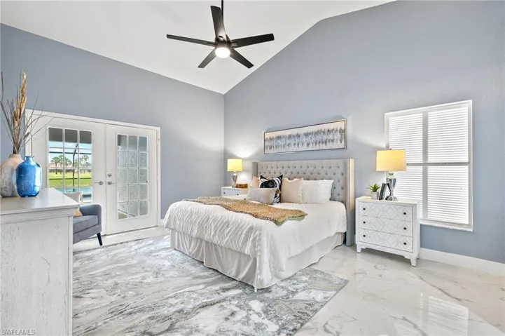 Bedroom featuring french doors, access to exterior, marble tiled flooring, high vaulted ceiling, and baseboards