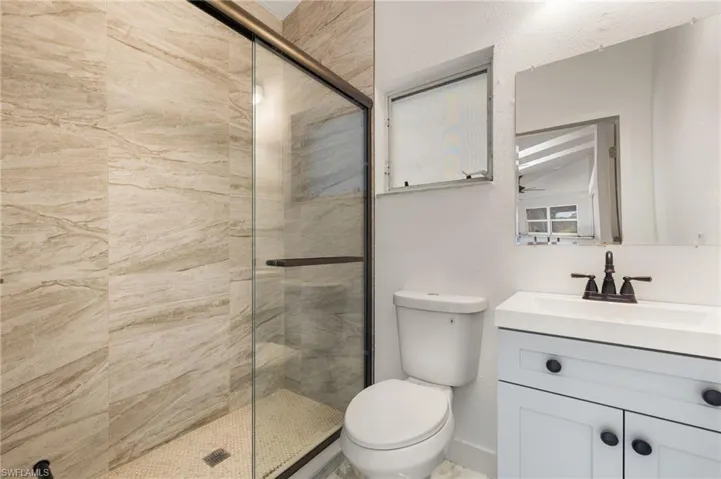 Bathroom with a shower stall, toilet, and vanity