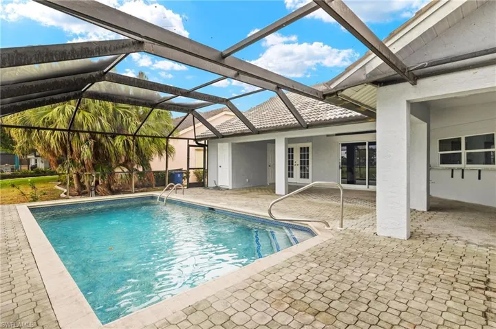 Swimming pool with french doors, a patio, and glass enclosure