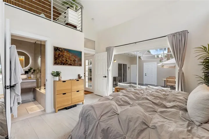 Bedroom with a high ceiling, a closet, and ensuite bath