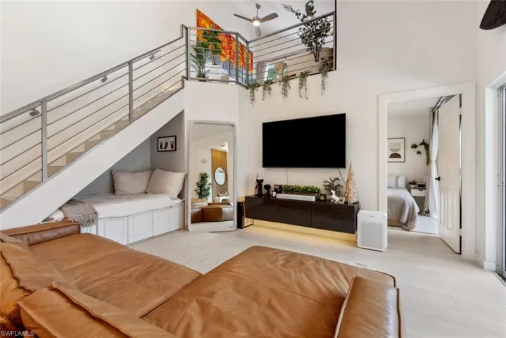 Living room featuring a wealth of natural light, a towering ceiling, and ceiling fan