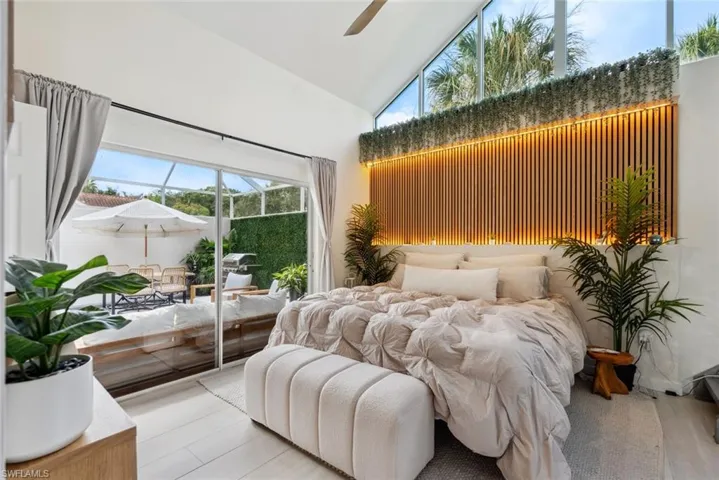 Bedroom with high vaulted ceiling, ceiling fan, and hardwood / wood-style floors