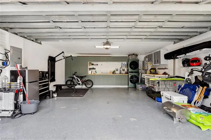 Garage with stacked washing maching and dryer and a workshop area