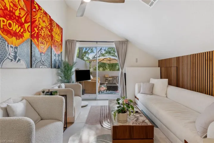 Tiled loft room featuring vaulted ceiling, ceiling fan and entry to roof top terrace
