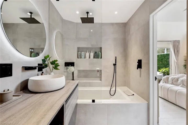 Bathroom with tile walls, tile flooring, and vanity