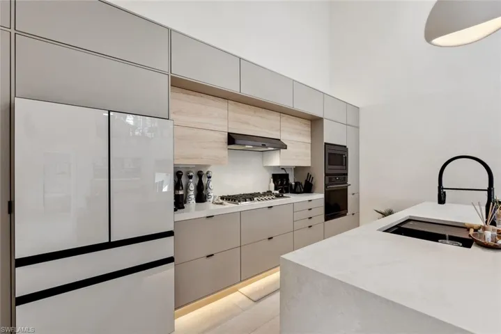Kitchen with appliances with stainless steel finishes, wall chimney range hood, sink, and tasteful backsplash