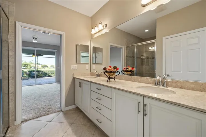 Bathroom with tile patterned flooring, vanity, and walk in shower