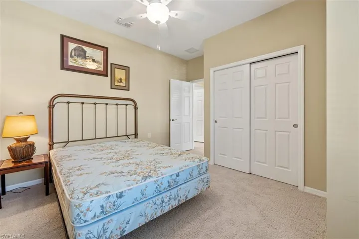 Bedroom featuring light carpet, a closet, and ceiling fan