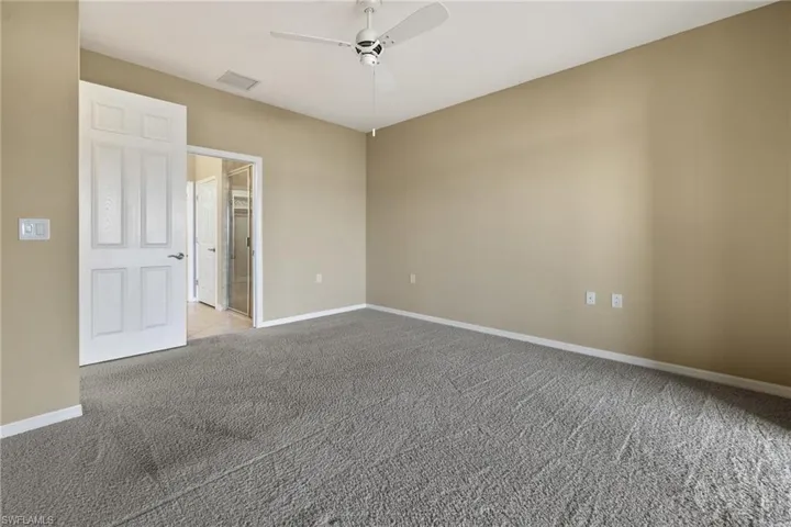 Spare room featuring light carpet and ceiling fan