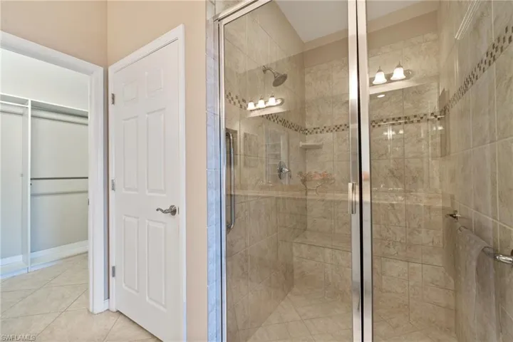 Bathroom with tile patterned flooring and a shower with shower door