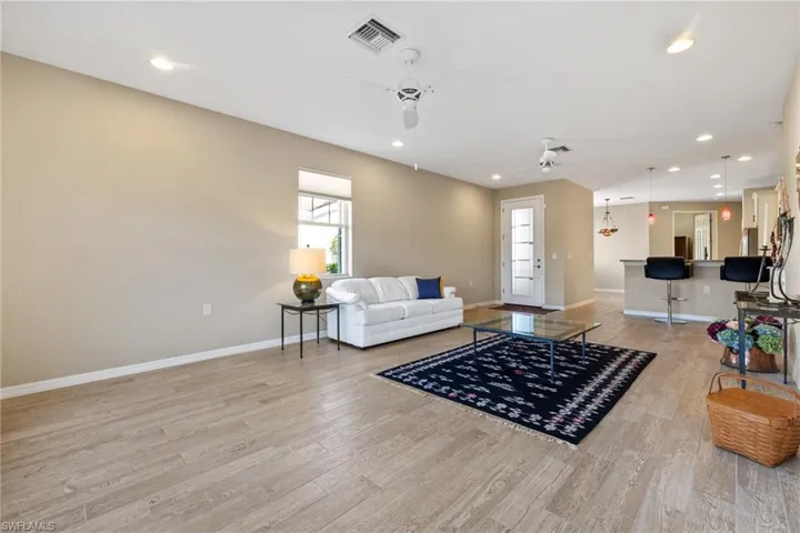 Living room with ceiling fan and light wood-type flooring