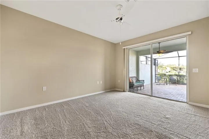 Carpeted spare room featuring ceiling fan