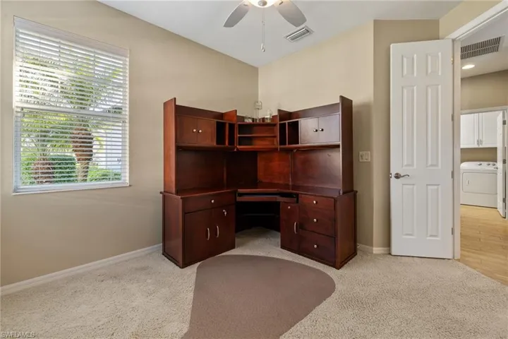 Carpeted home office featuring washer / clothes dryer and ceiling fan