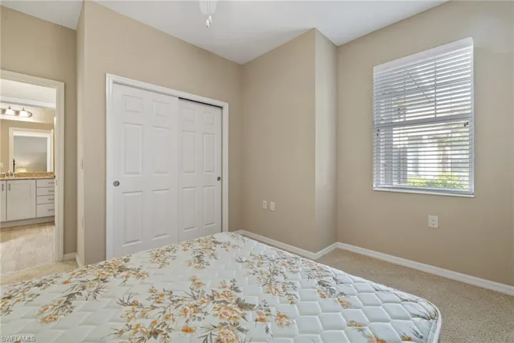 Unfurnished bedroom featuring ceiling fan, light colored carpet, and a closet