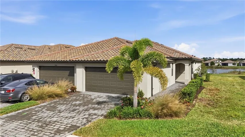 View of front of home with stucco siding, decorative driveway, and a tile roof