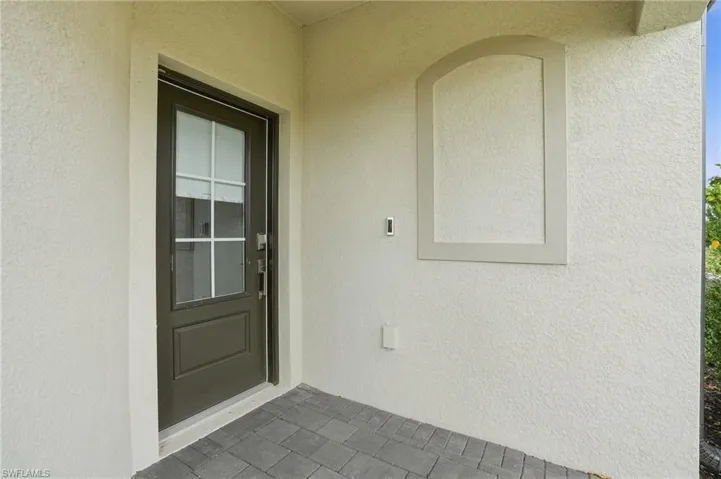 Doorway to property with stucco siding and a patio area