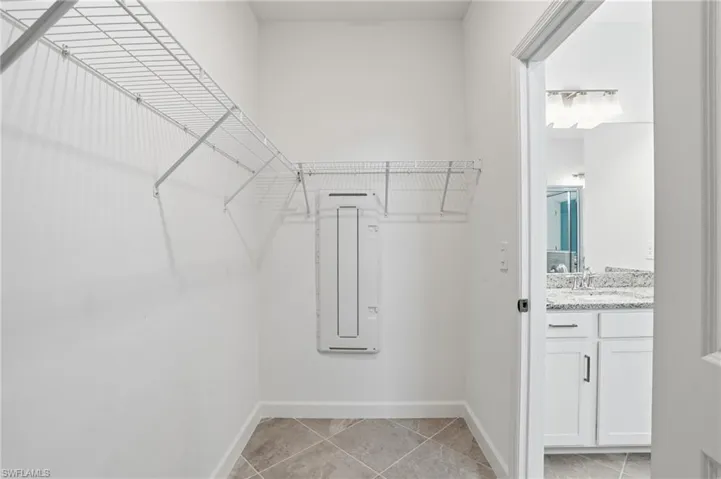 Spacious closet featuring light tile patterned floors and a sink