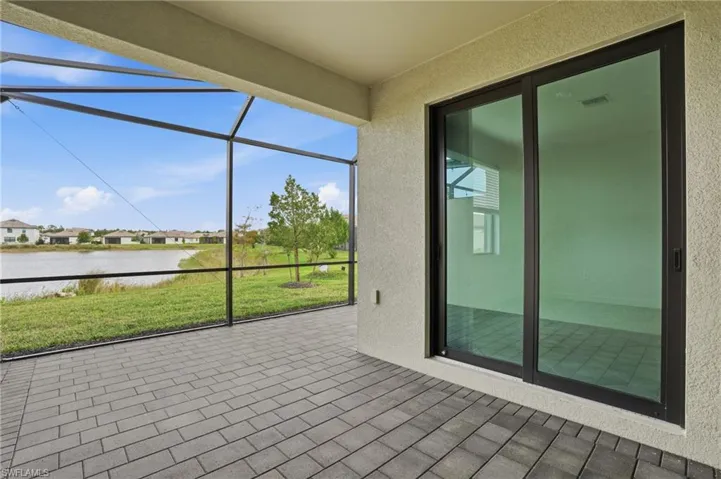 Unfurnished sunroom featuring a patio area, a water view, and a residential view