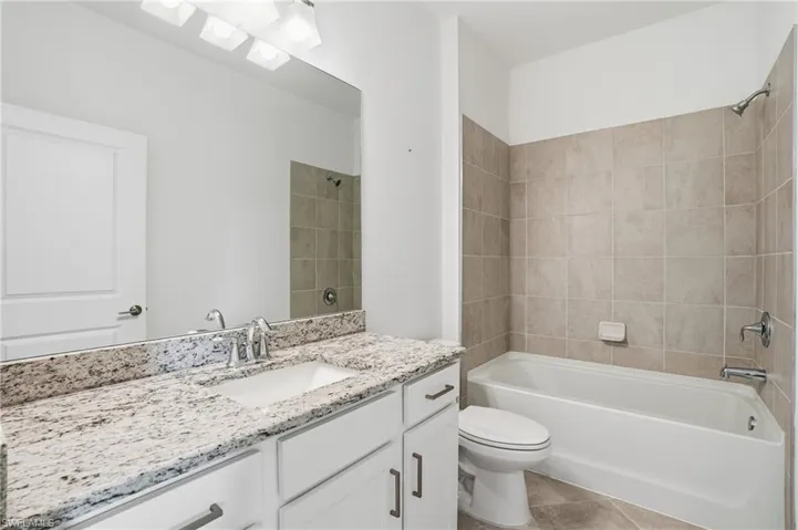 Full bath featuring vanity and washtub / shower combination