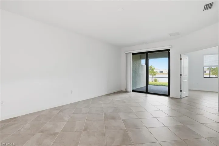 Empty room featuring plenty of natural light and light tile patterned flooring