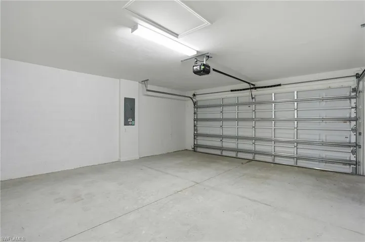 Garage with electric panel and a garage door opener