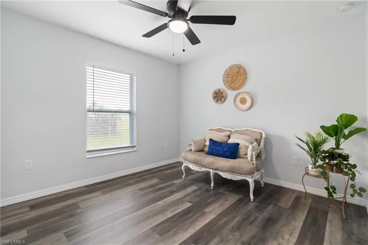 Sitting room with baseboards, wood finished floors, and ceiling fan