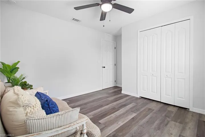 Living area featuring ceiling fan, baseboards, wood finished floors, and visible vents