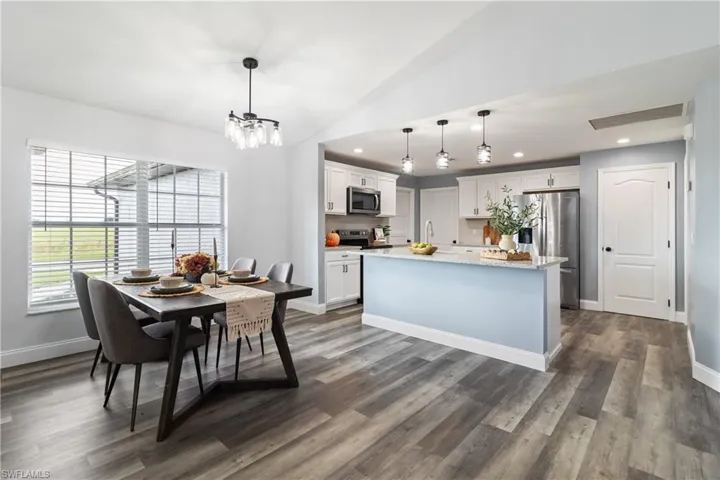 Dining space featuring lofted ceiling, visible vents, recessed lighting, and dark wood finished floors