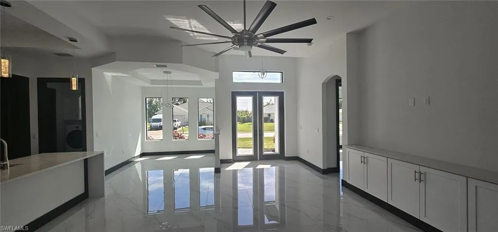 Entryway featuring washer / dryer, arched walkways, marble finish floor, and baseboards