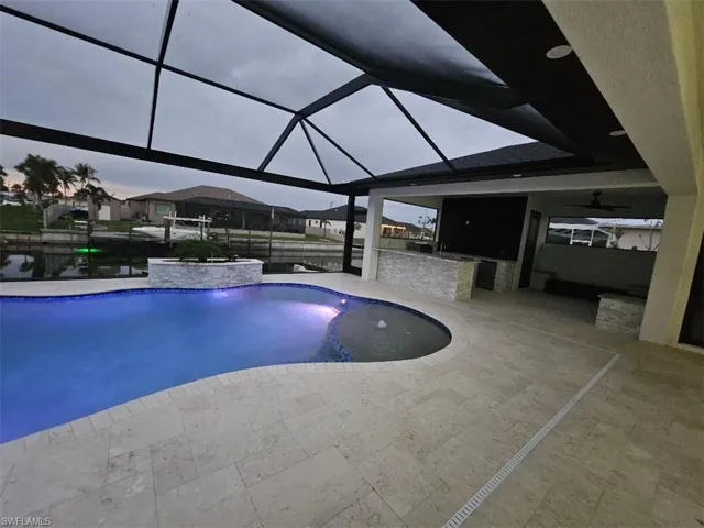 Pool featuring glass enclosure and a patio