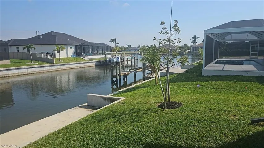 Dock area featuring a yard, a water view, a lanai, and a residential view