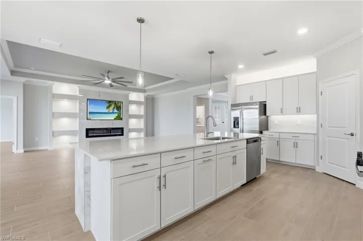 Kitchen featuring a large center island with a sink, white cabinetry, and stainless steel appliances