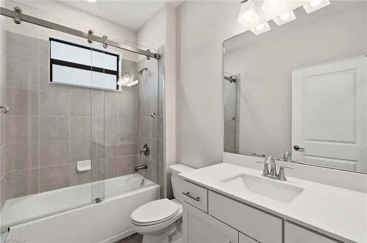 Contemporary bathroom featuring a white vanity with an integrated sink, brushed nickel faucet, and a large wall-mounted mirror